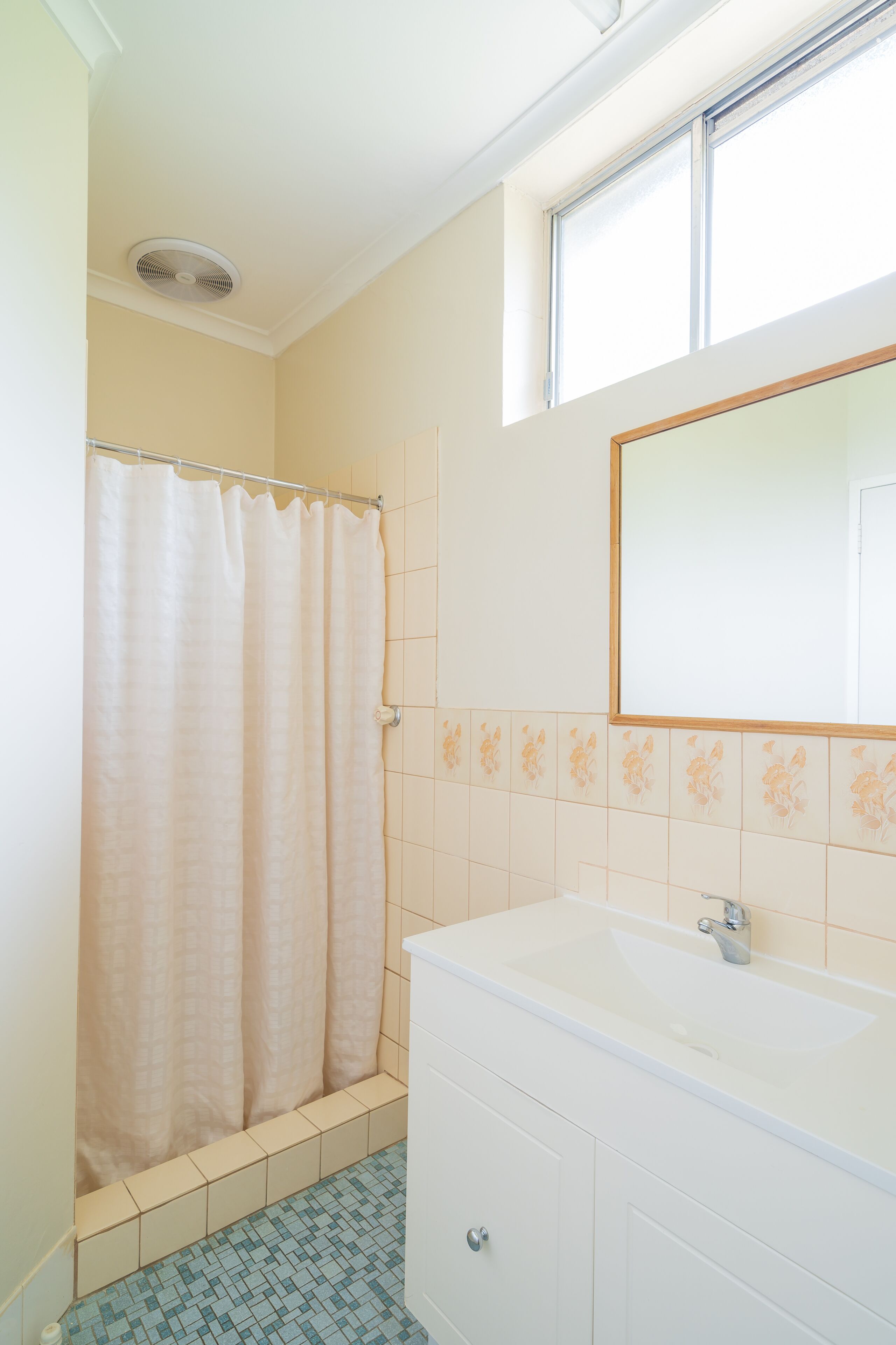 Un baño con cortina de ducha, un lavabo y un espejo.