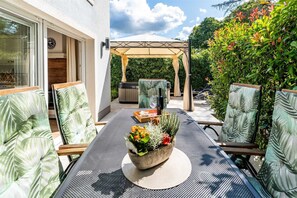 A patio with a table set for dining, outdoor seating, and a pergola. - Holiday House Andrea (Malinska)