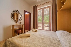 Een hotelkamer met een bed, een bureau, een stoel en een raam met gordijnen.