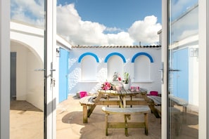Courtyard dining area with outdoor furniture, al fresco entertaining at large holiday home near Rhosneigr, Anglesey