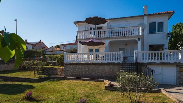A two-story building with a balcony, a garage, and a well-maintained lawn. - Apartment Anka 2 with Balcony (Krk)