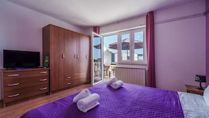 A bedroom with a bed, a wardrobe, a television, and a window with a view. - Apartment Anka 2 with Balcony (Krk)