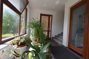 Stunning hallway with potted plants and a glass-panelled door.
