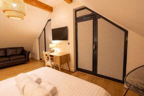 Ein Schlafzimmer mit Bett, Schreibtisch, Stuhl, Fernseher und Kleiderschrank.