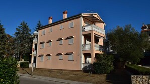 Um edifício com vários andares, teto plano, varandas e céu limpo.
