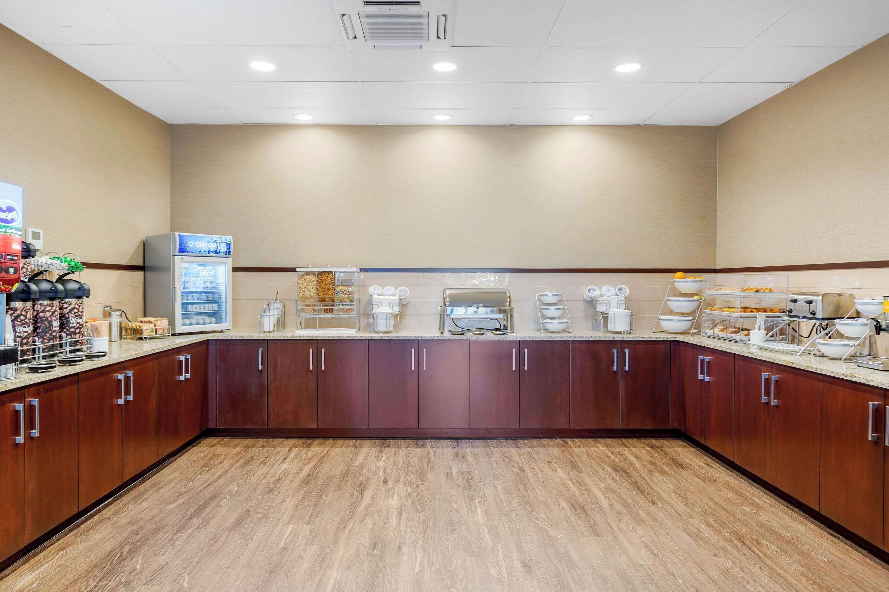 A hotel kitchen with a long counter, various appliances, and storage cabinets.