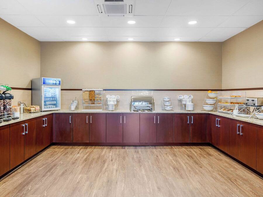 A hotel kitchen with a long counter, various appliances, and storage cabinets.