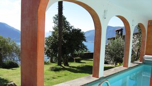 Une piscine avec vue sur les montagnes et un arbre.