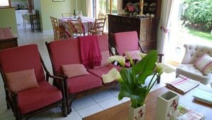 Ein Wohnzimmer mit einer Sofagarnitur, einem Couchtisch und einem Bücherregal.