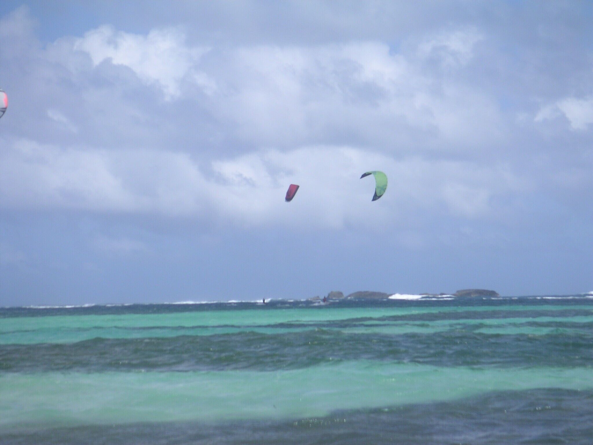 A coastal scene with clear turquoise waters and overcast skies.