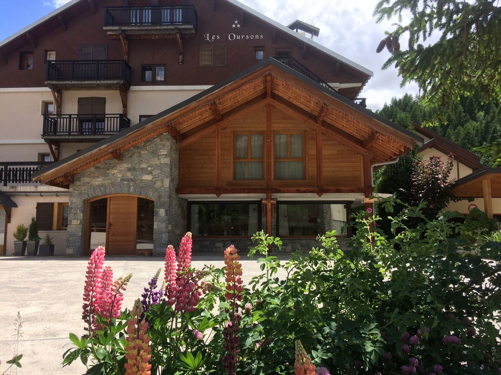 A wooden lodge with balconies and a stone entrance.