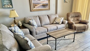 Un salon avec un canapé, un fauteuil et une table basse.