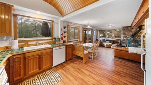 Una cocina amplia con armarios de madera, un comedor con mesa y sillas, y una zona de estar acogedora con un sofá.