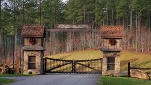 Uma entrada com portão e uma placa com a inscrição 'Thirsty Ridge'.