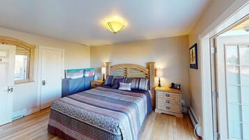 Un dormitorio con cama, mesitas de noche, lámpara, calefactor y contenedores de almacenamiento en la pared.