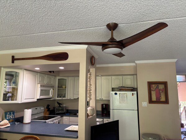 A kitchen with white cabinets, a microwave, a toaster, and a refrigerator.