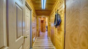 A wooden hallway with doors on the left and a coat rack on the right. - Horse Ranch on the Yellowstone River. Close to Gardiner and Yellowstone Park. (Emigrant)