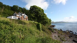 Une maison traditionnelle de style Tudor, dotée d’un grand jardin et offrant une vue sur le lac.
