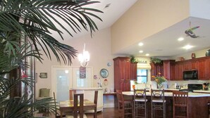 A spacious kitchen with wooden cabinets, a central island, and a dining area with chairs.