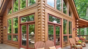 A log cabin with a deck featuring rocking chairs and a bench. - Serenity Retreat (Formerly Leins Lodge) Luxury Home Stunning Mountain Views (Maggie Valley)