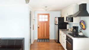 Une cuisine compacte équipée d’une cuisinière, d’un four à micro-ondes et d’un réfrigérateur.
