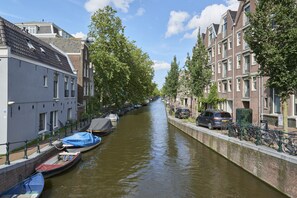 Ein Kanal, gesäumt von Booten, Fahrrädern und traditionellen Gebäuden.