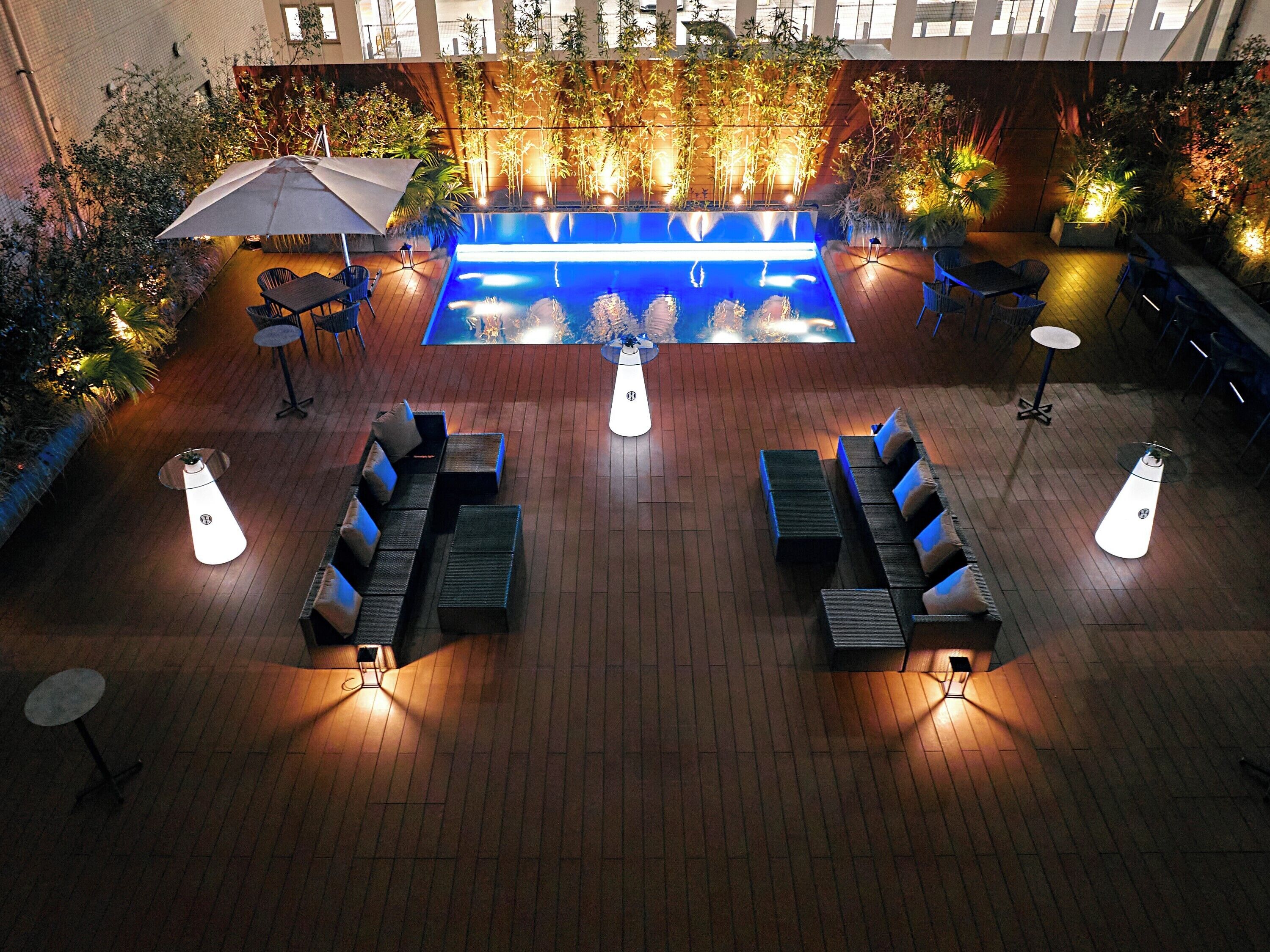 Un espace extérieur aménagé avec une piscine, des chaises longues et des tables.