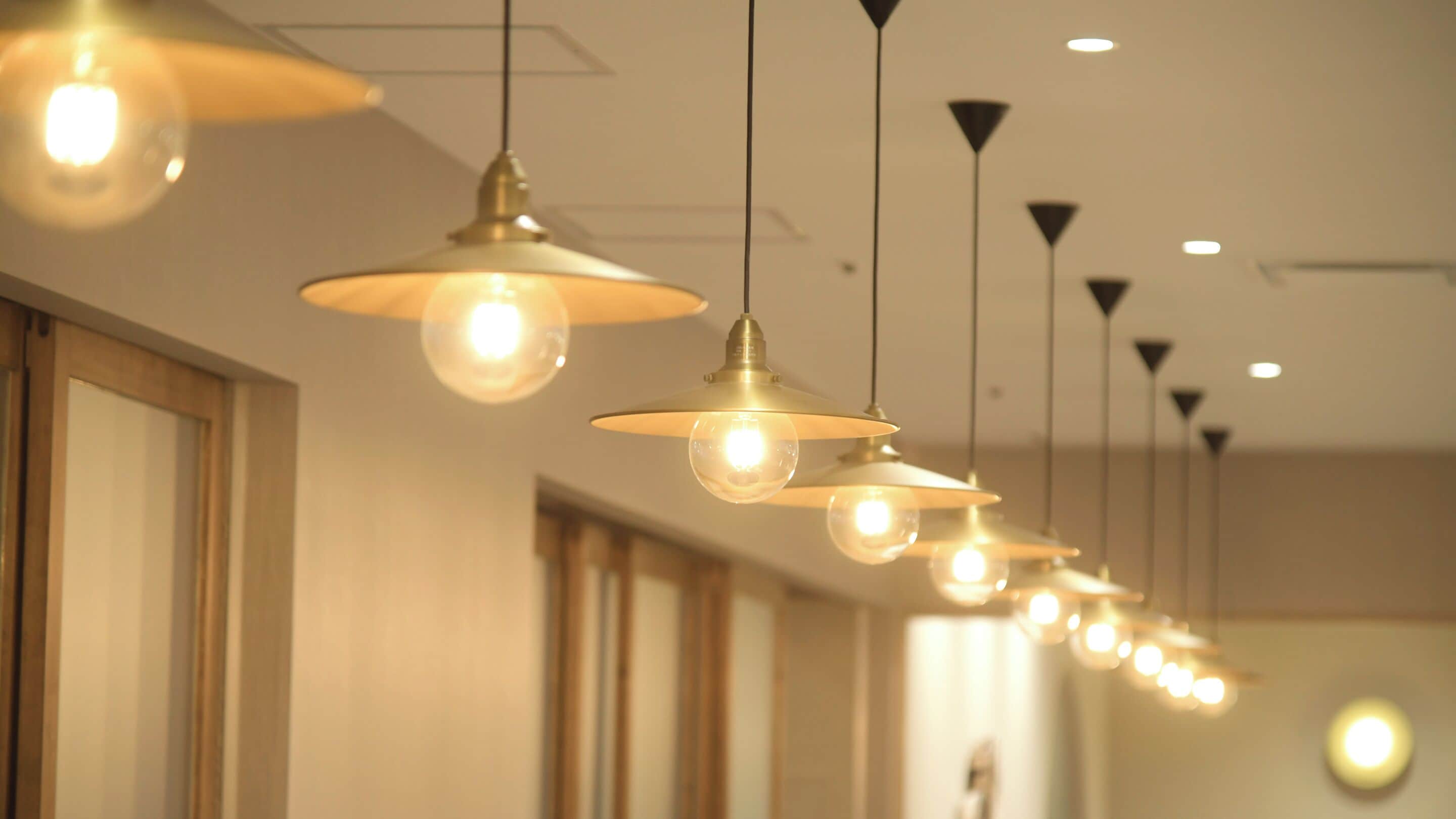 A series of pendant lights hanging from the ceiling in a hallway.