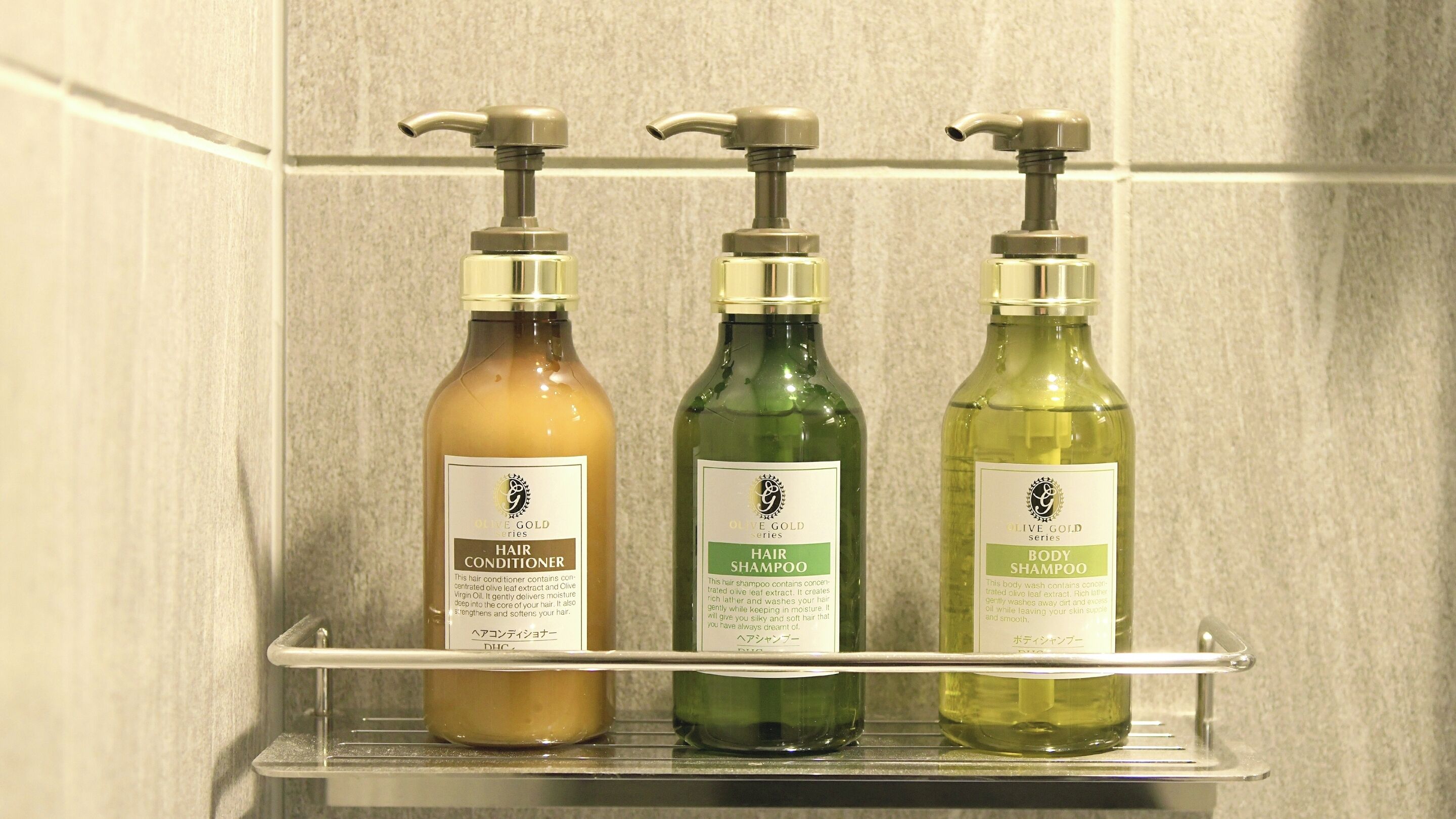 Tres botellas de productos para el cabello y el cuerpo sobre una estantería.