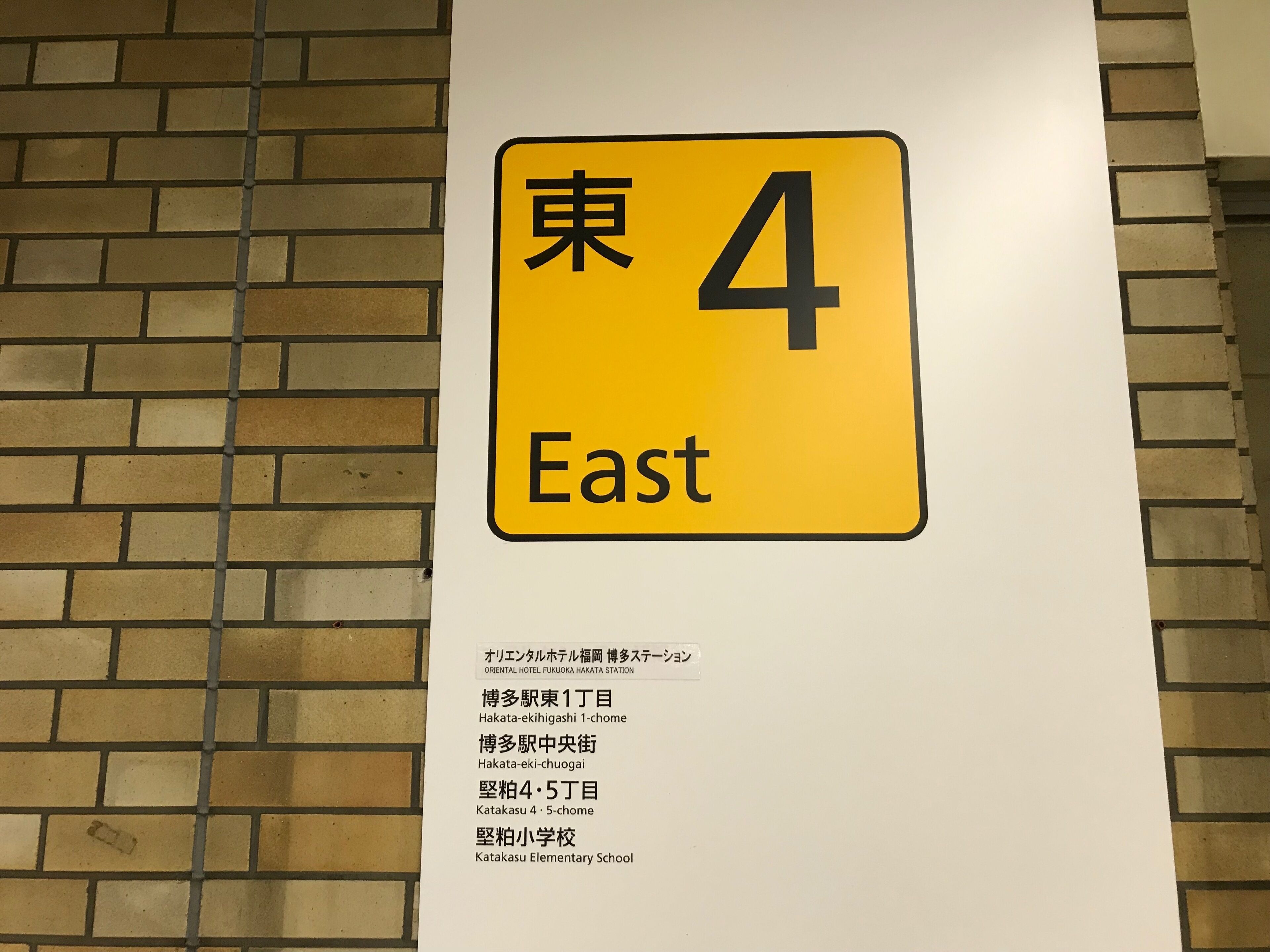 Une pancarte indiquant « 東 4 Est » ainsi qu’une liste des noms et adresses des hôtels.