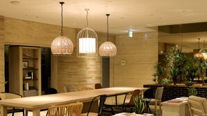 A modern conference room with a long table, chairs, and hanging pendant lights. - Oriental Hotel Fukuoka Hakata Station (Fukuoka)