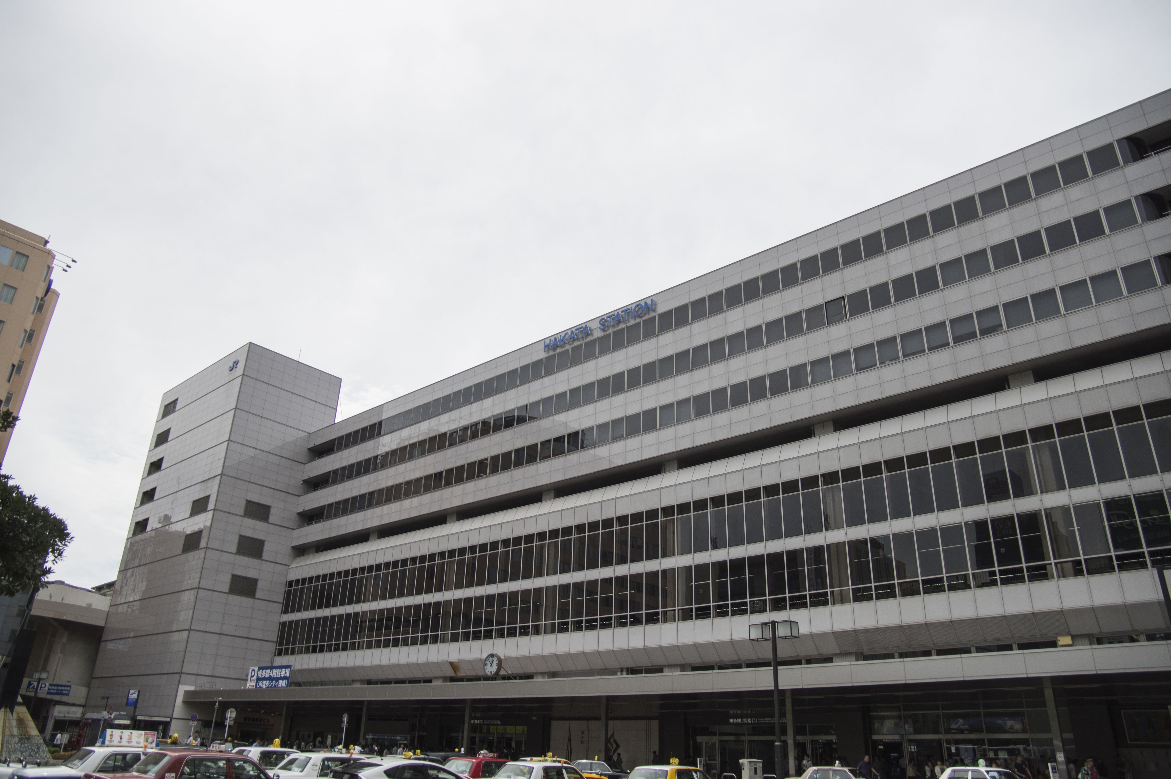 A multi-story parking garage with a modern design, featuring a clock and signage indicating it is a public parking facility.