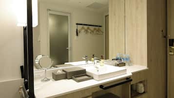 Un baño moderno con un lavabo blanco, un espejo y un perchero para toallas.