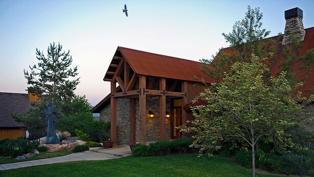 Un bâtiment de style rustique, doté d’une façade en pierre, de poutres en bois et d’un toit rouge.