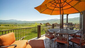 Un balcon avec une table et des chaises, un barbecue et une vue sur la campagne.