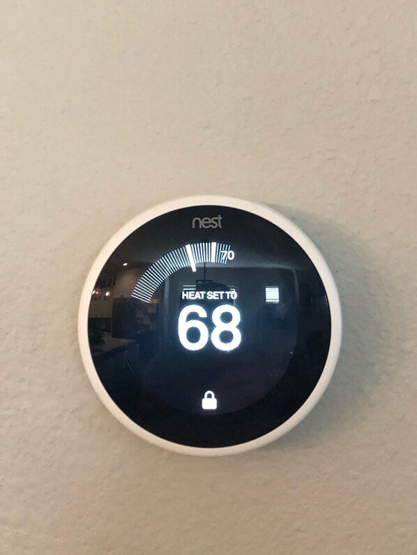 A Nest thermostat mounted on a wall displaying a heat set to 68 degrees. - Newly built private garage apartment in Little Rock's Heights neighborhood! (Little Rock)
