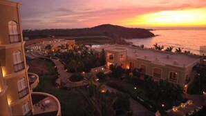 Un resort con vista a la playa, varias edificaciones y zonas ajardinadas.