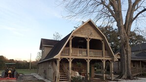 Ein Holzhaus mit einer Veranda und einer Treppe, die zu einem zweiten Stock führt.