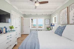 A bedroom with a bed, dresser, and ceiling fan.