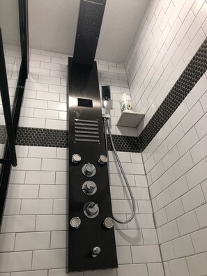 Een bad/douchecombinatie, een haardroger, handdoeken, zeep
