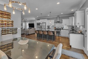 A modern kitchen with white cabinets, stainless steel appliances, and a central island with bar stools.