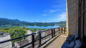 A balcony with a view of a lake and mountains.