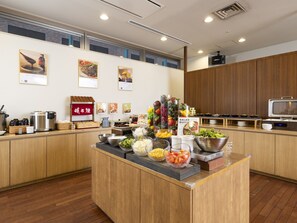 A buffet setup with various food items and a microwave. - KOKO HOTEL Kobe Shinnagata (Kobe)