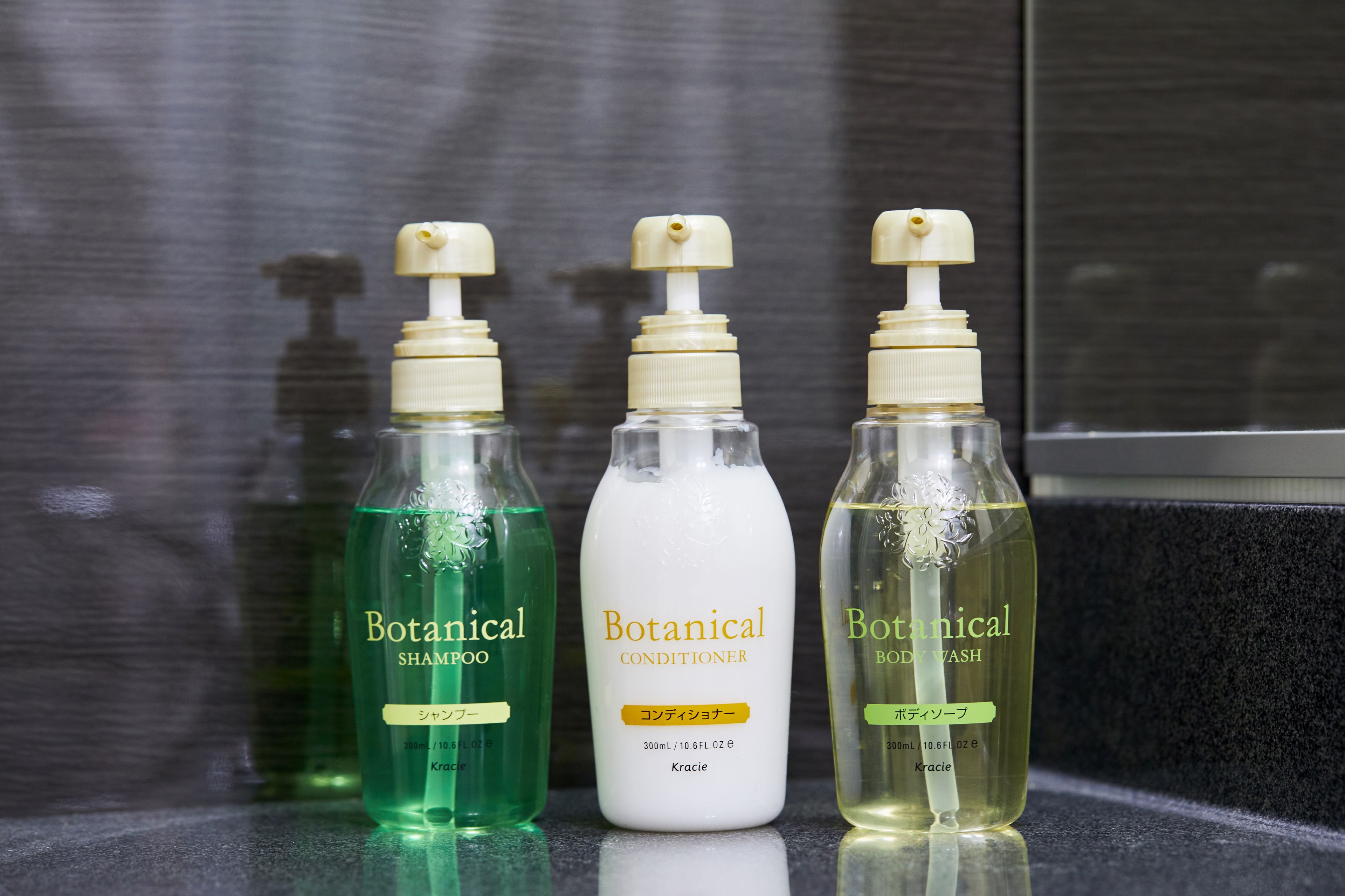 Three bottles of Botanical products on a reflective surface.