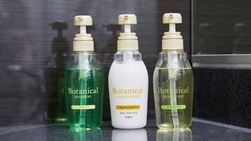 Three bottles of Botanical products on a reflective surface.