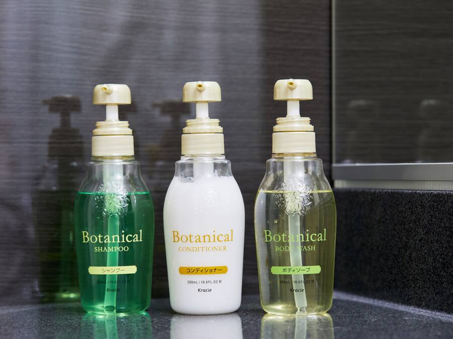Three bottles of Botanical products on a reflective surface.