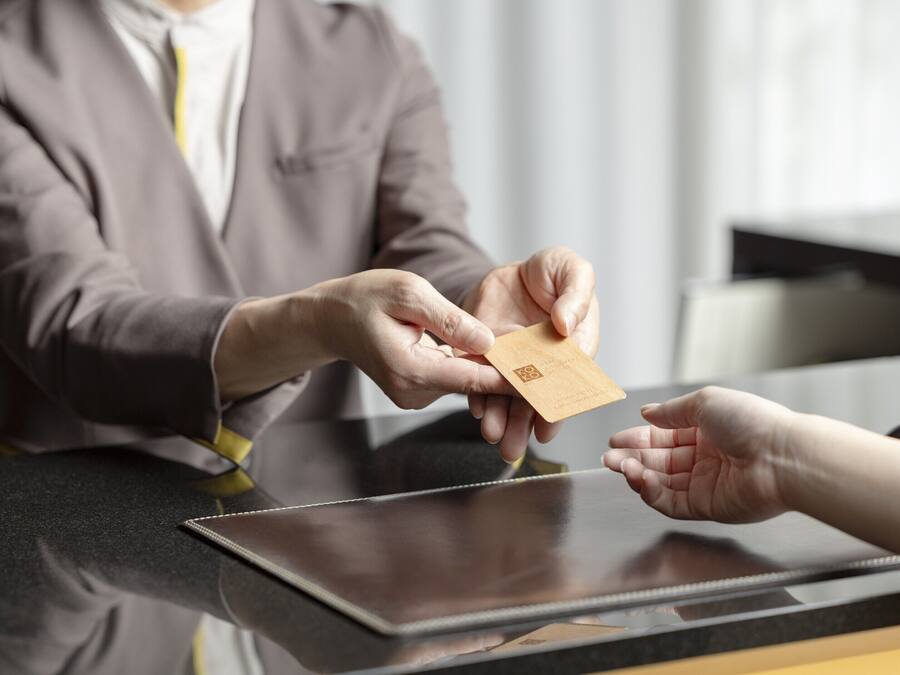 A person handing over a card to another person at a counter.