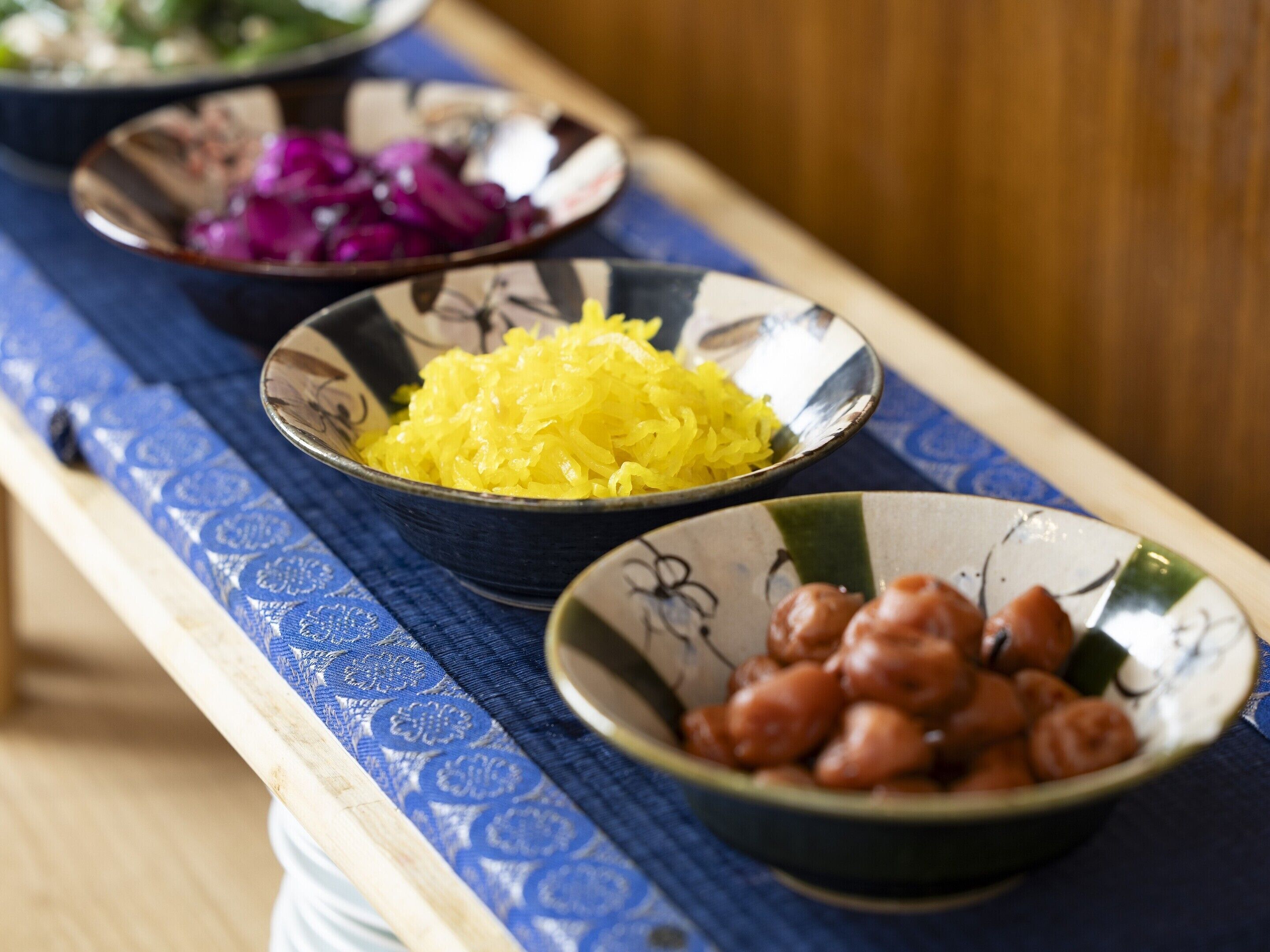 Una mesa con tres recipientes que contienen distintos alimentos.