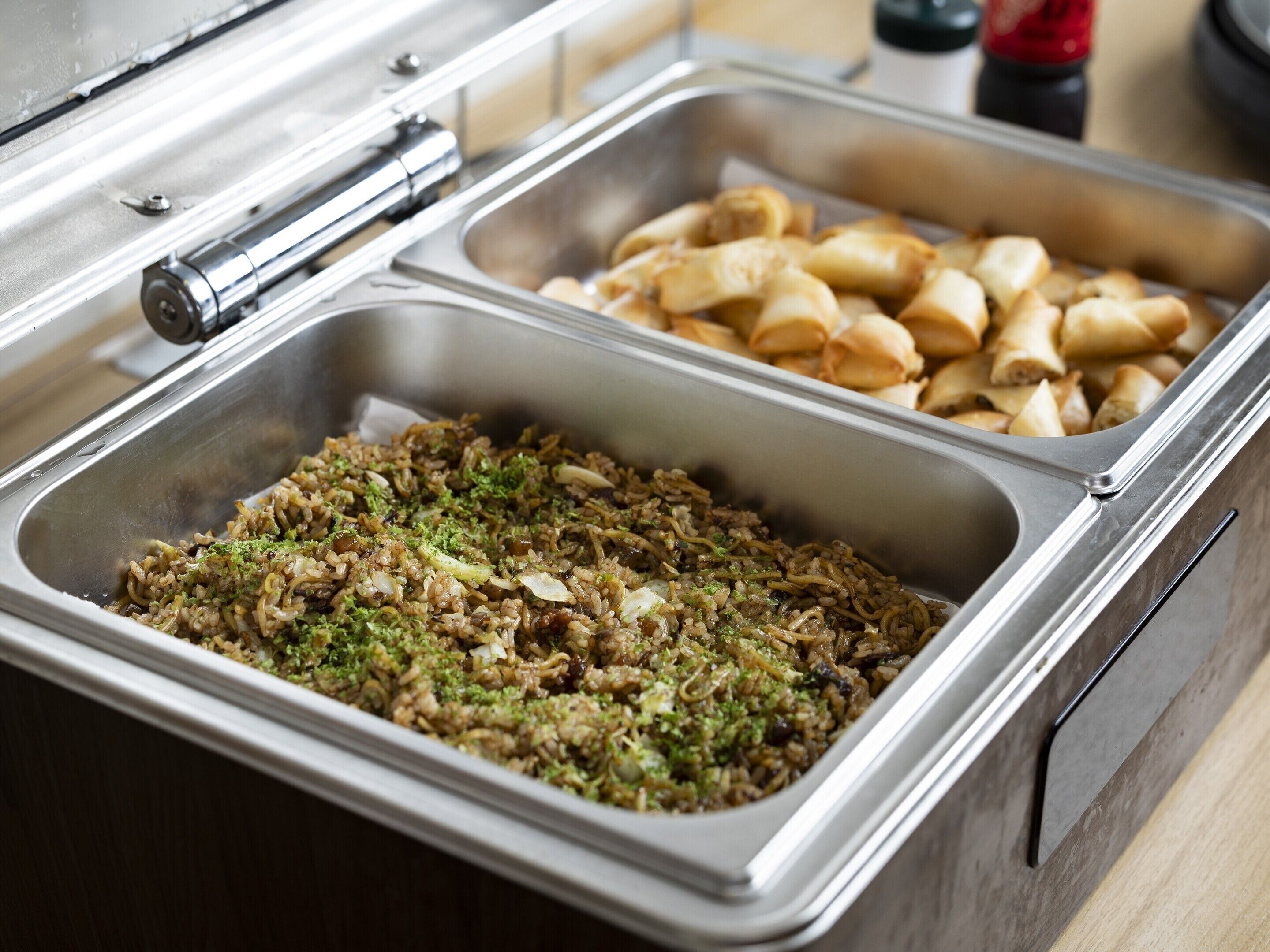Un buffet proposant une variété de plats, dont un assortiment de légumes sautés et un autre de plats frits.