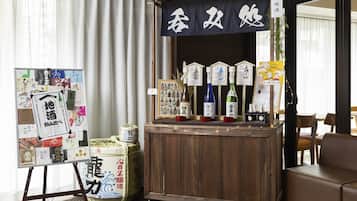 A room with a wooden bar area displaying various bottles, a bulletin board with papers, and a traditional Japanese sign.